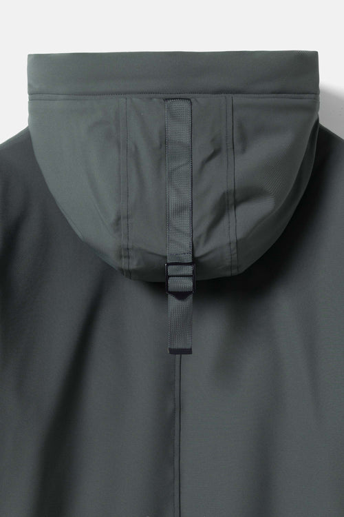 Close-up of the hood and upper front of a dark gray waterproof jacket, showing a vertical seam and a black plastic hook-and-loop strap closure.