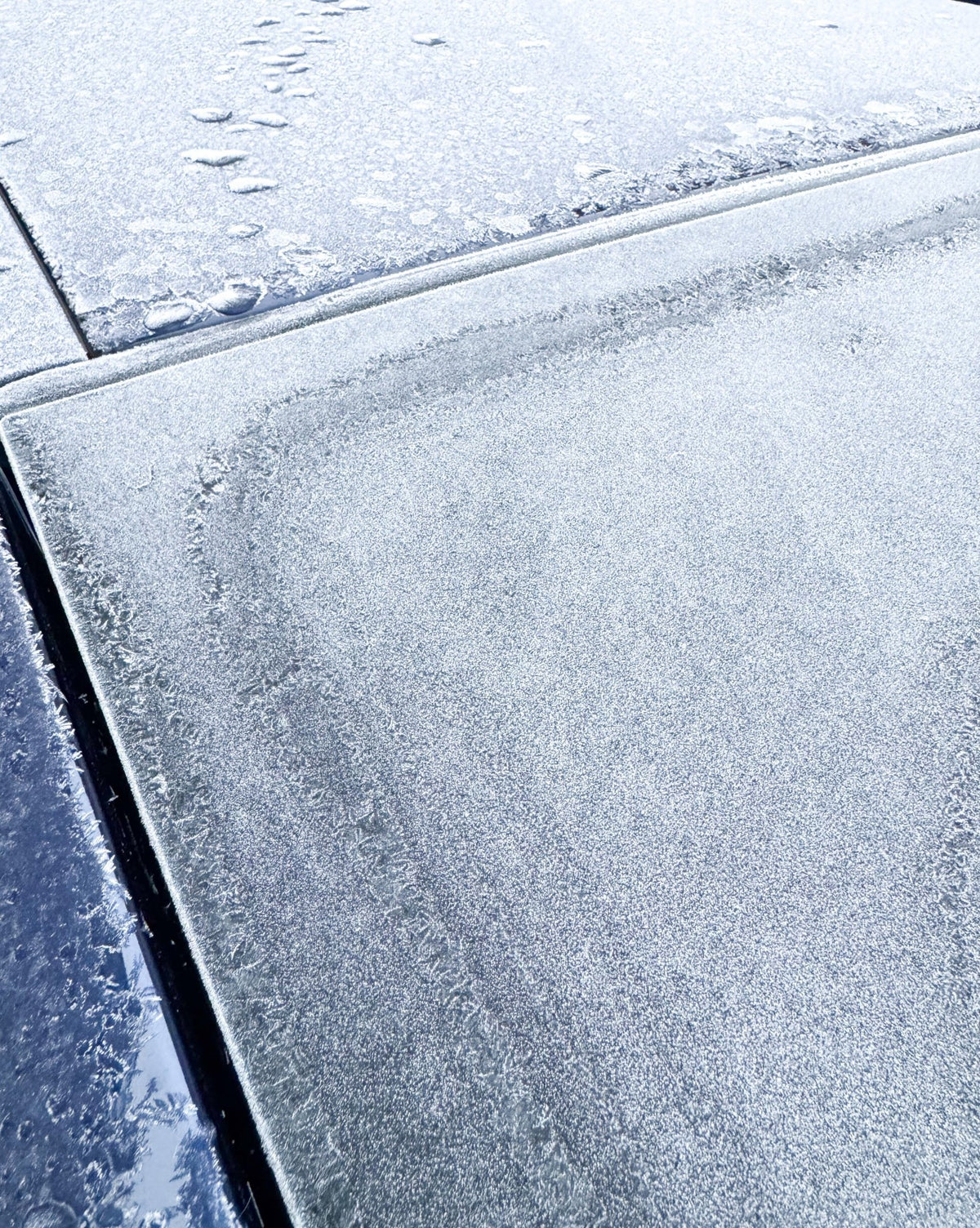 Närbild på frost som täcker mörka stenplattor
